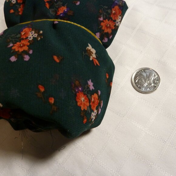 Fabric with pink, red, and fuchsia floral pattern on a forest green background - Picture 3 of 3